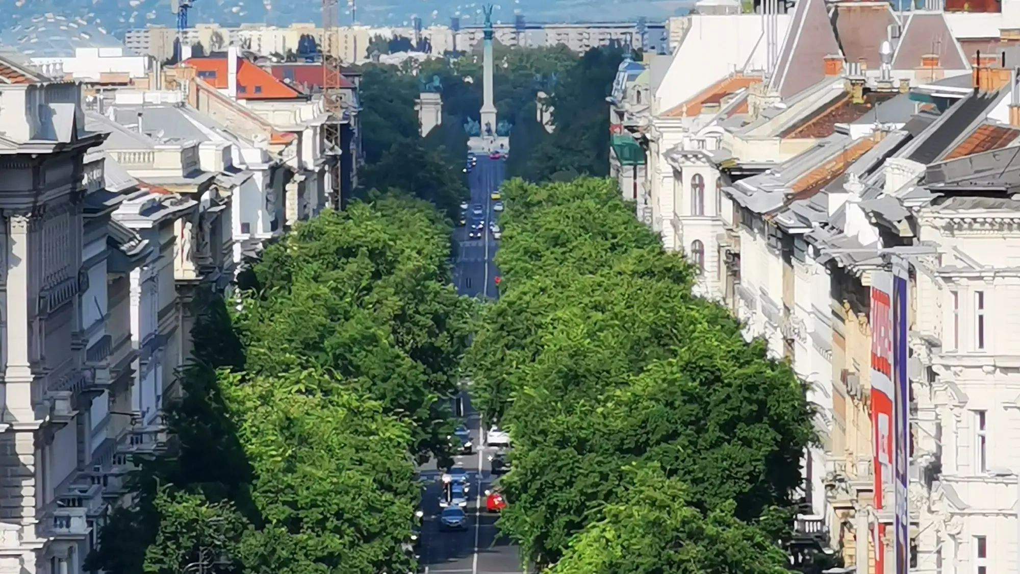 Andrássy Avenue seen from above, a double line of plane trees running between palace facades towards the Millennium Monument at Heroes' Square