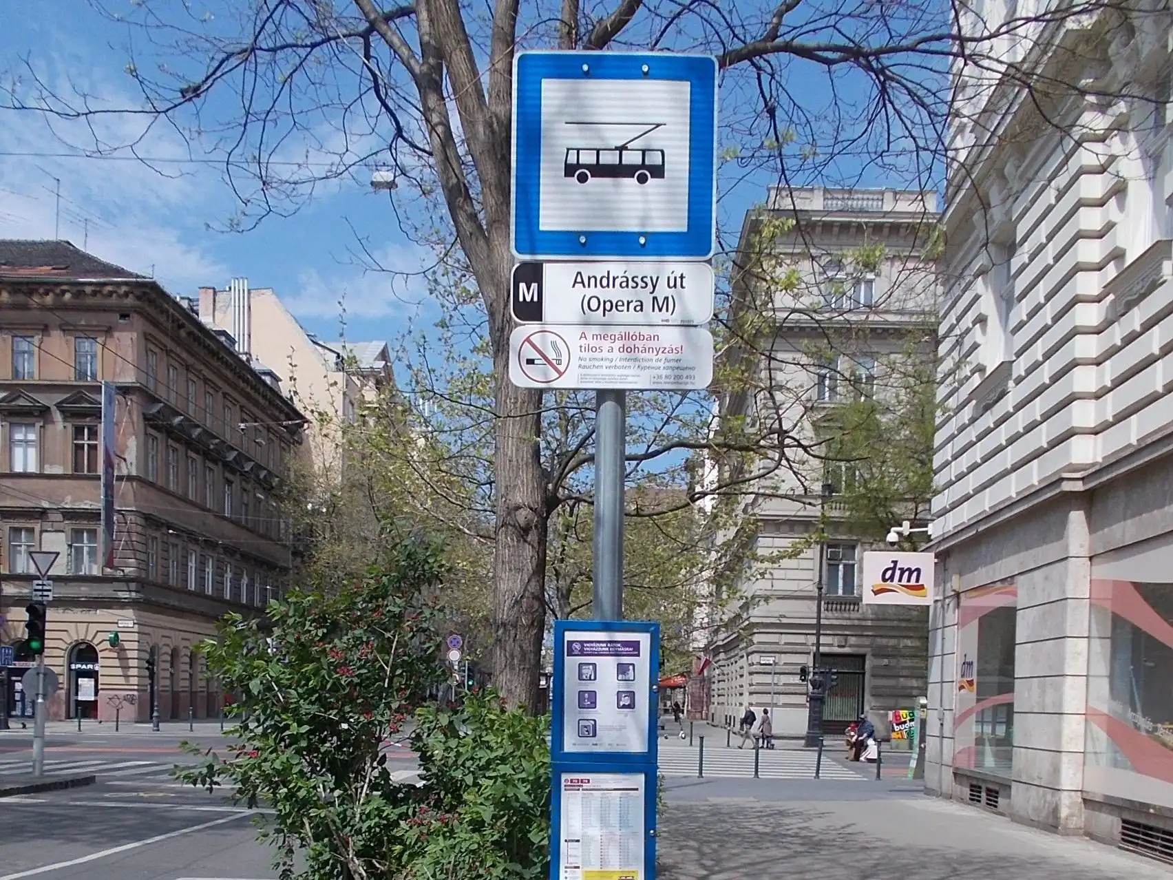 The Andrássy út (Opera M) trolleybus stop sign on the pavement of Andrássy Avenue in Budapest, with its timetable case below