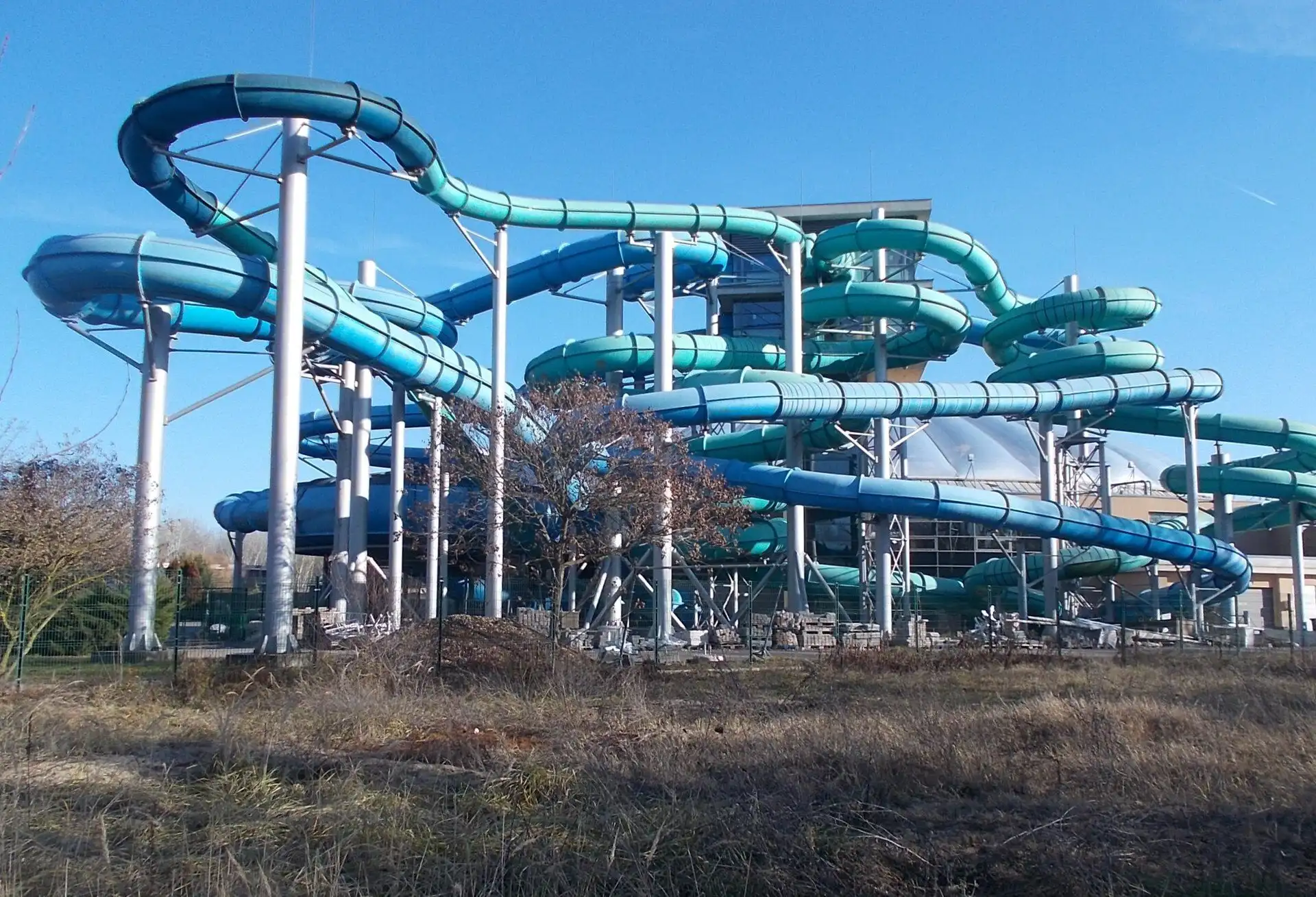 The blue and turquoise tubes of Aquaworld's giant slides looping outside the dome before turning back in