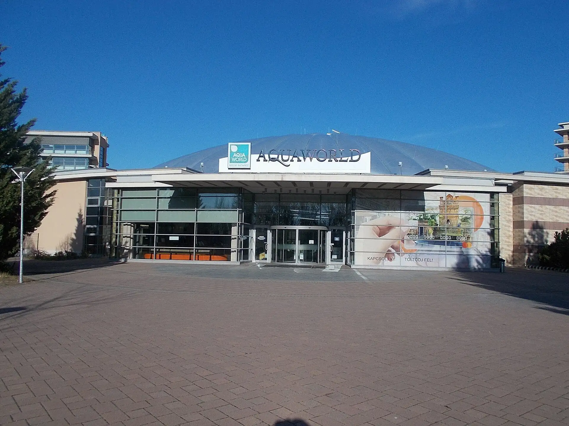 The entrance to Aquaworld's water park under its blue AQUAWORLD sign, with the dome behind and the hotel to the left