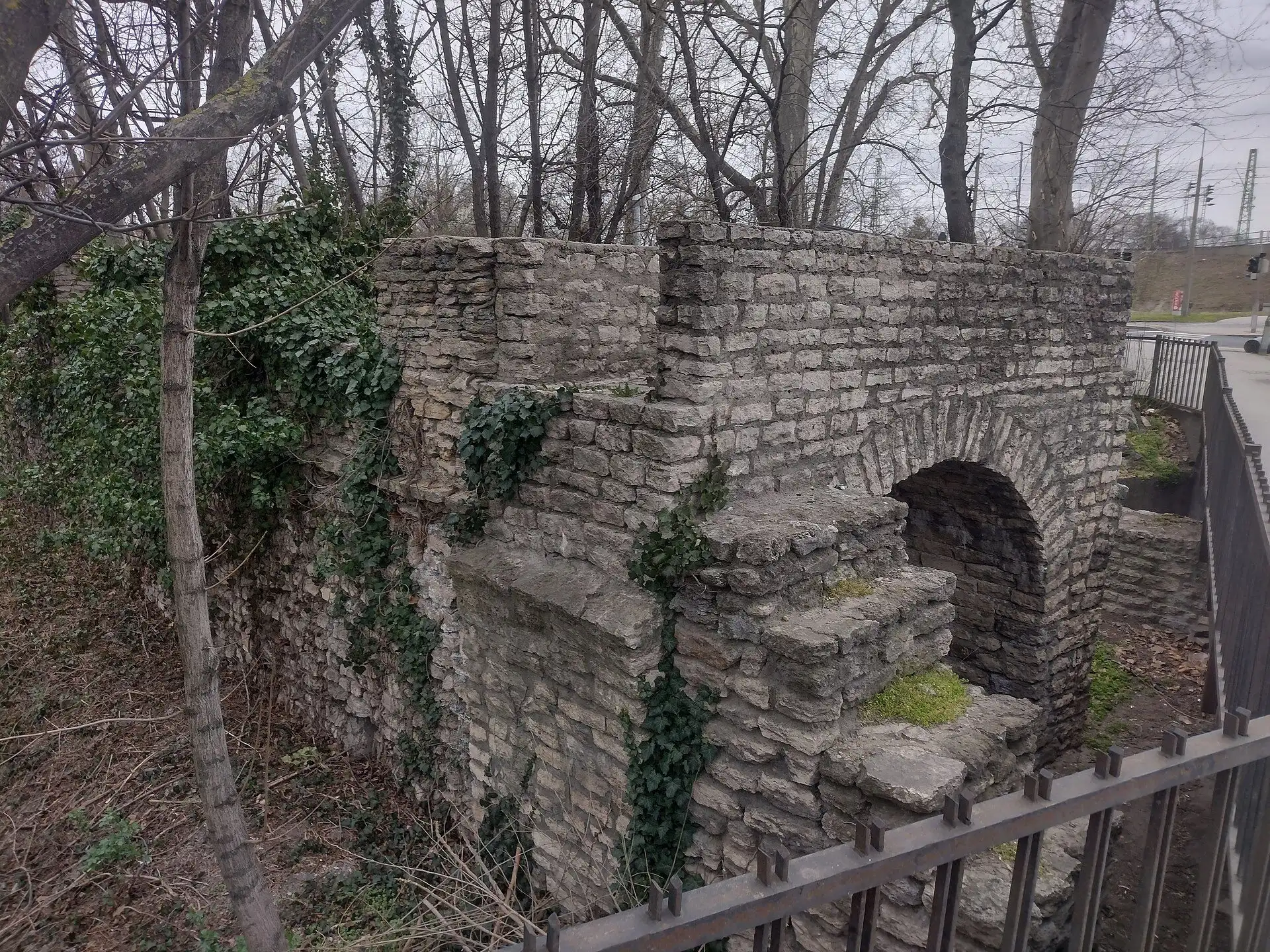 Roman masonry where the Aquincum aqueduct meets the town wall, with an arched opening through the stonework