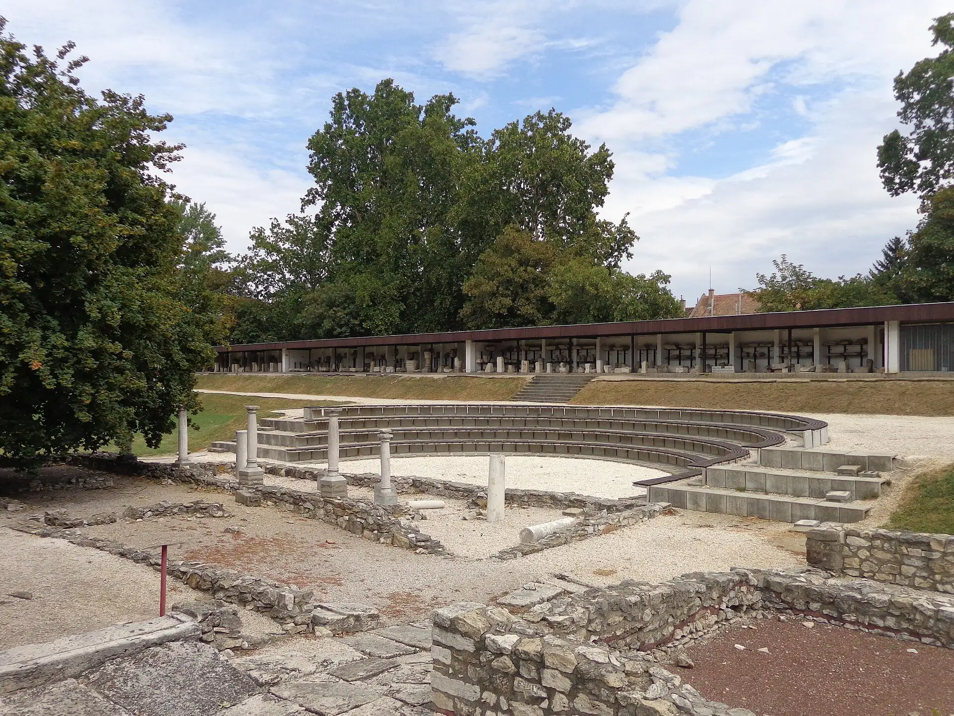 The modern open-air theatre in the Aquincum Archaeological Park, with Roman wall footings in front of it and the long Lapidarium colonnade behind