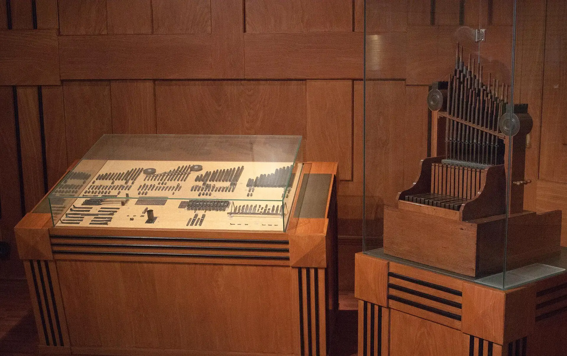 The surviving pipes and fittings of the Aquincum organ laid out in a flat case, with the working reconstruction standing beside it