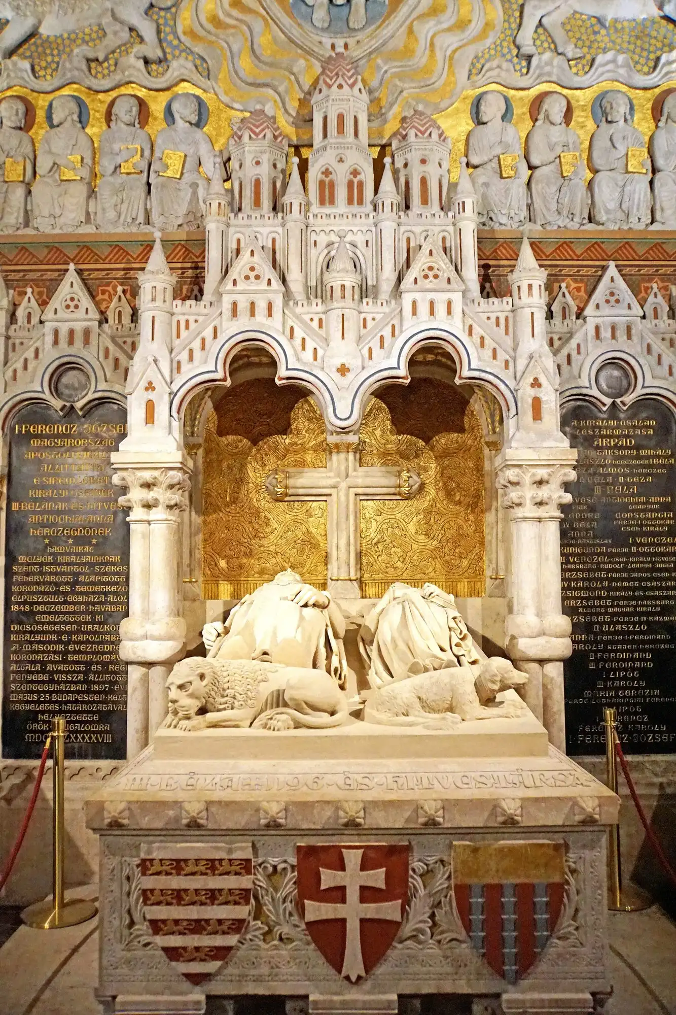The canopied white stone double sarcophagus of King Béla III and Anne of Antioch in Matthias Church, with lions at its foot and gilded reliefs behind