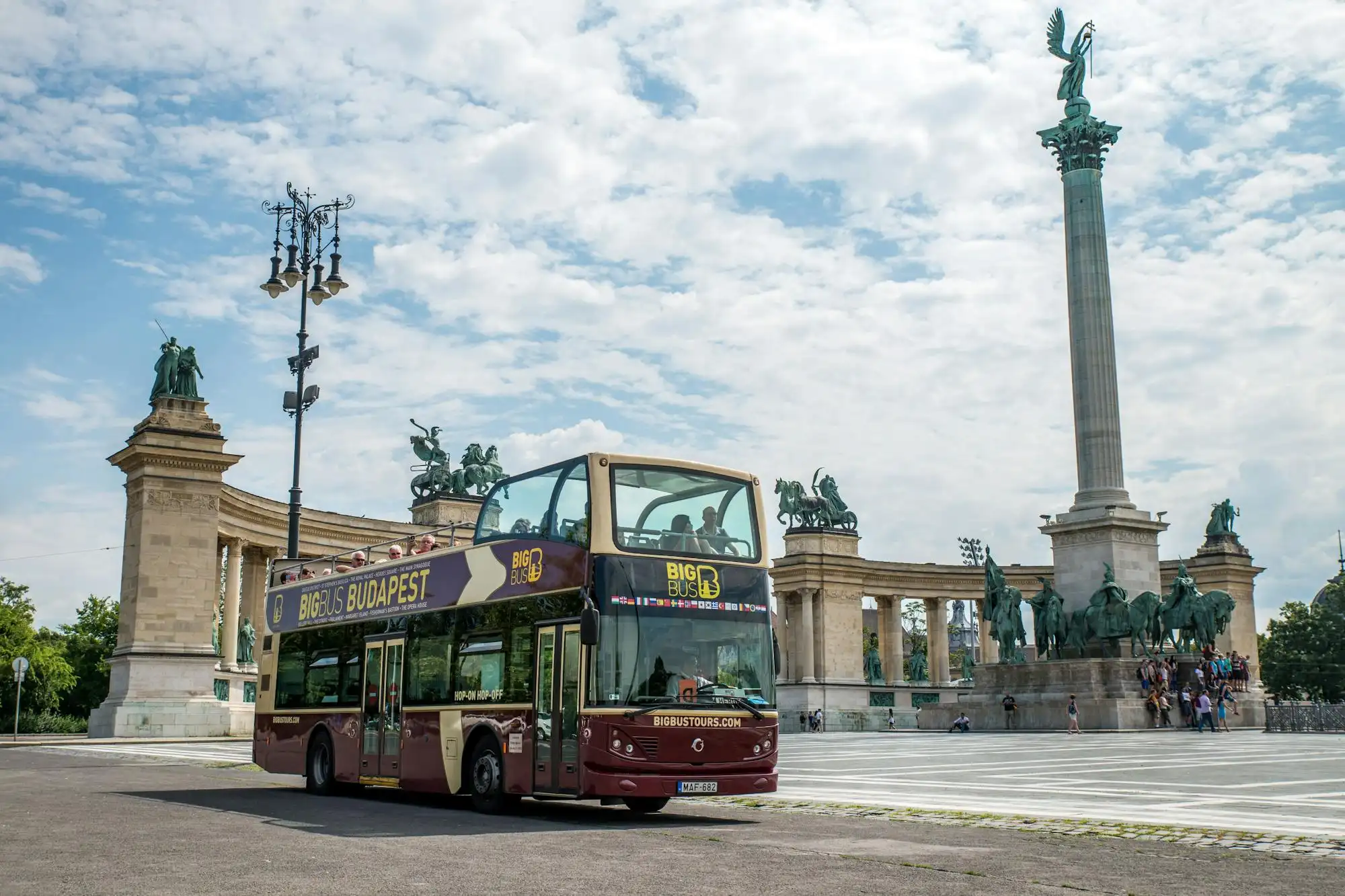 A Big Bus open-top double-decker passing the Millennium Monument on Heroes' Square in Budapest