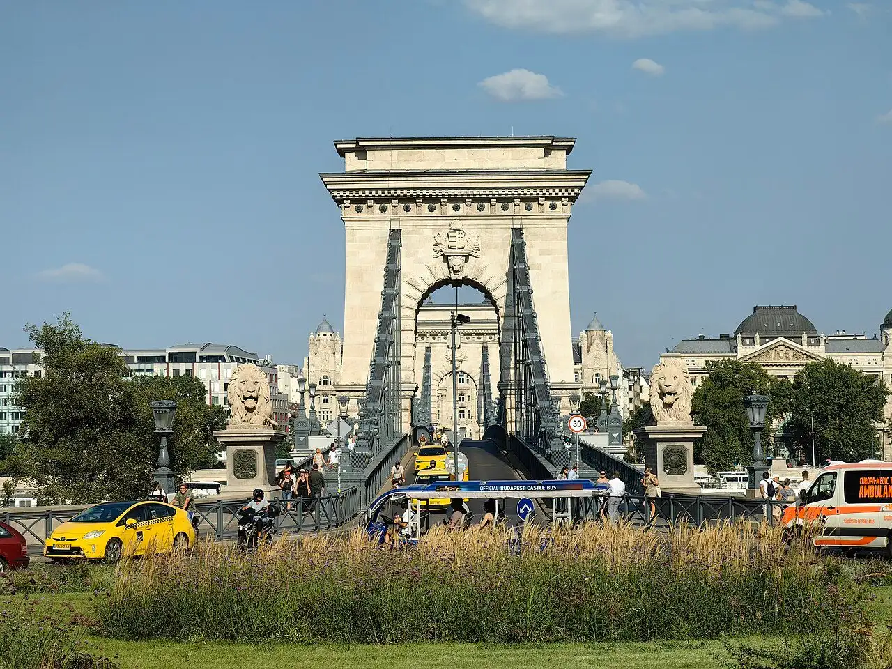 The Buda river pier of the Chain Bridge seen head on from Clark Ádám tér, with its arched gateway, the chains running down to the deck and a lion on its plinth at each side