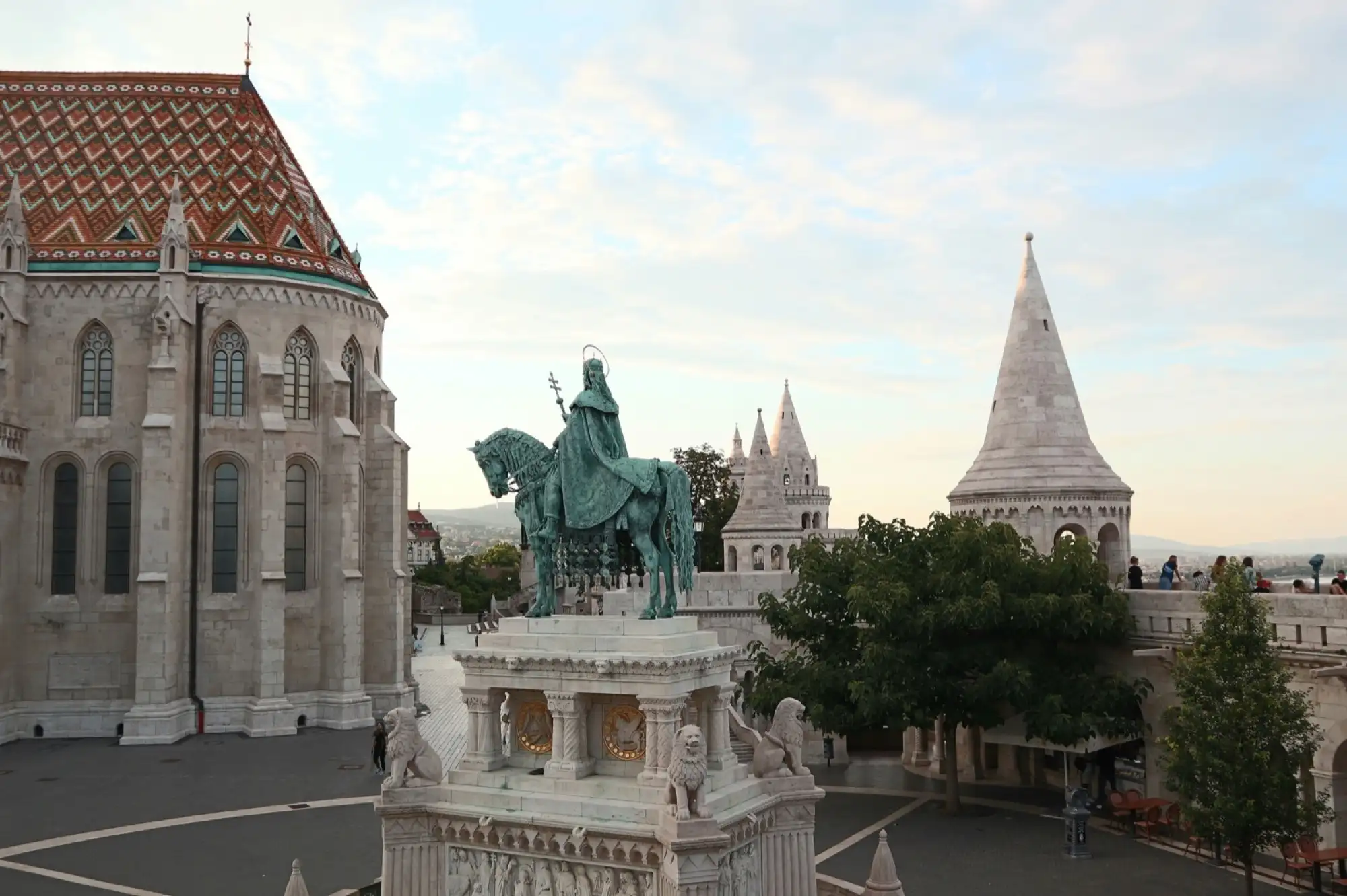 The bronze equestrian statue of St Stephen on its carved stone plinth, between Matthias Church and the turrets of Fisherman's Bastion