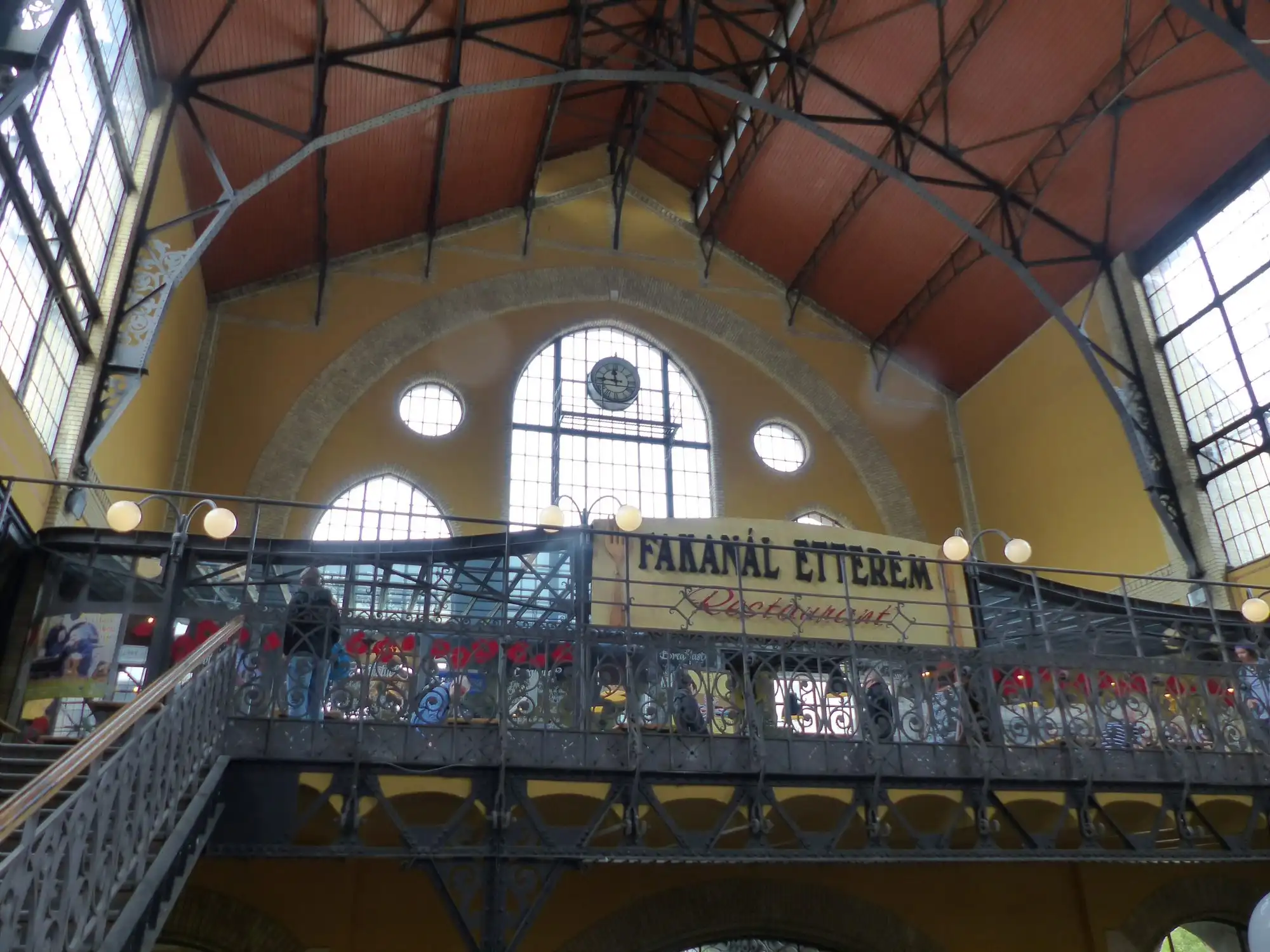 The gallery of the Great Market Hall in Budapest seen across the nave, with the Fakanál restaurant sign along the balcony under the iron roof