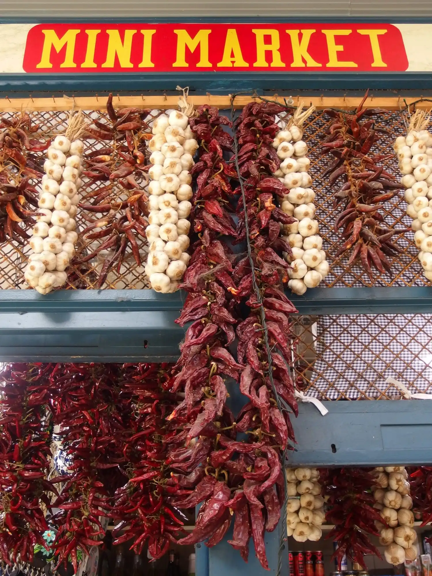 Strings of dried red paprika and garlic hanging from a stall front on the ground floor of the Great Market Hall in Budapest