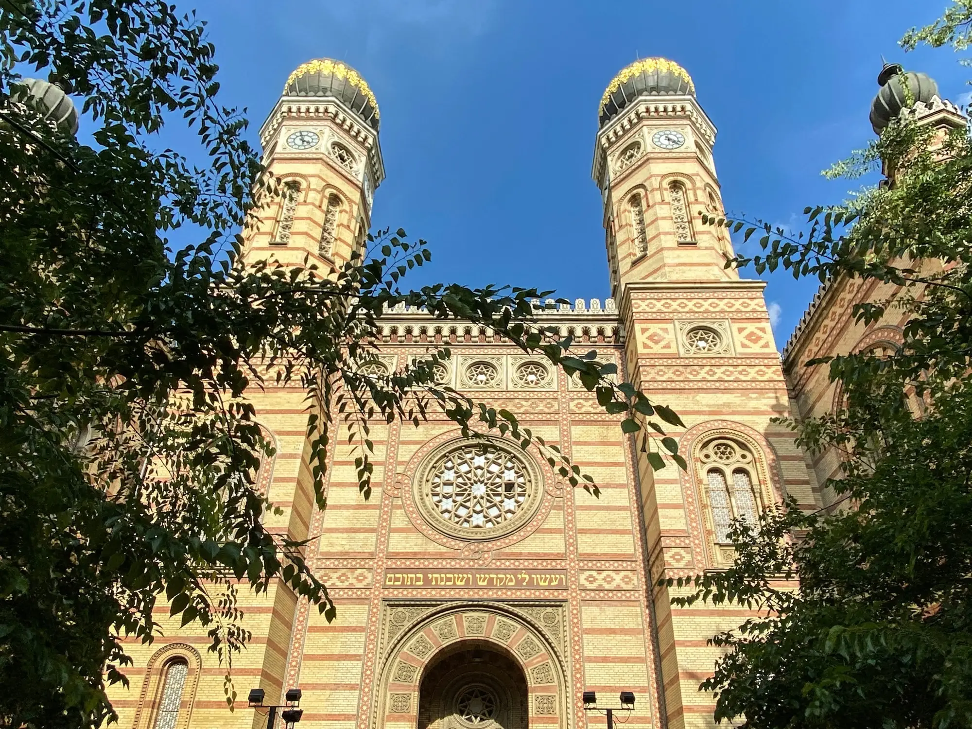 The striped brick facade of the Dohány Street Synagogue in Budapest, with its rose window and two onion-domed towers