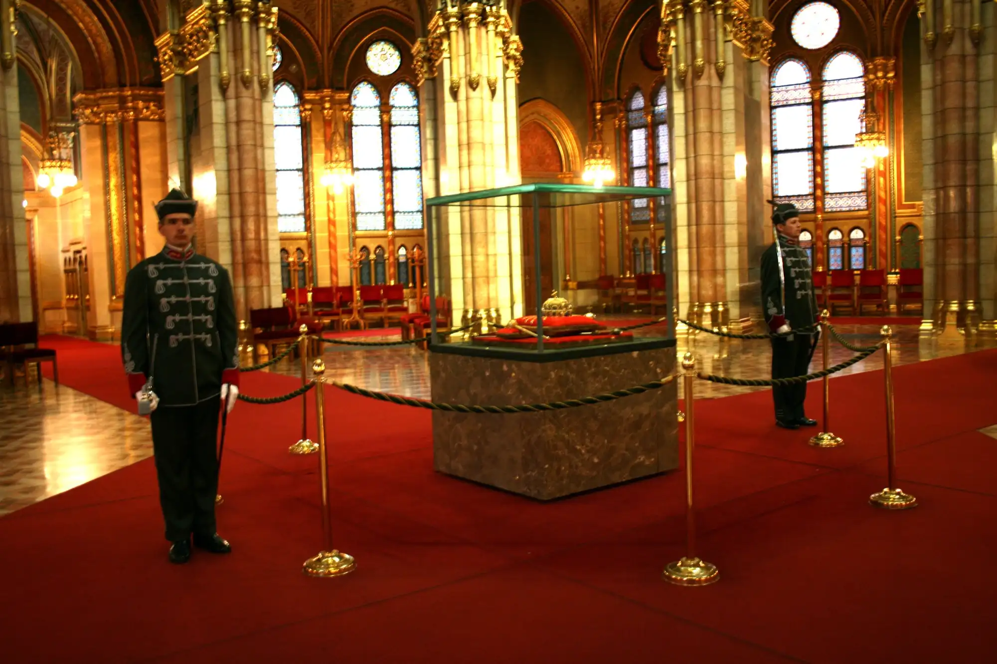 The Holy Crown of Hungary in its glass case in the Dome Hall of the Parliament, with two members of the Crown Guard standing either side
