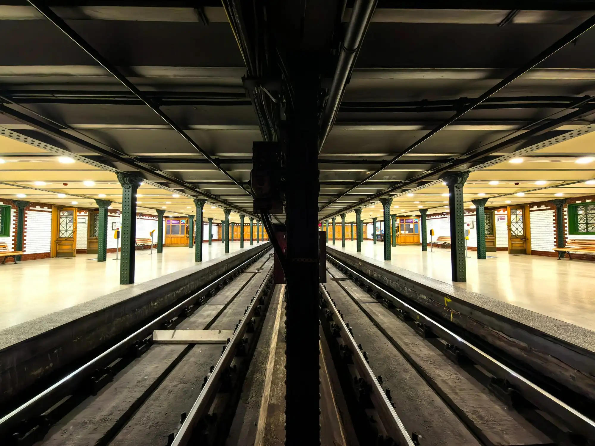 The tiled vaulted platform of Hősök tere station on the M1 Millennium Underground in Budapest, with its green and white station furniture