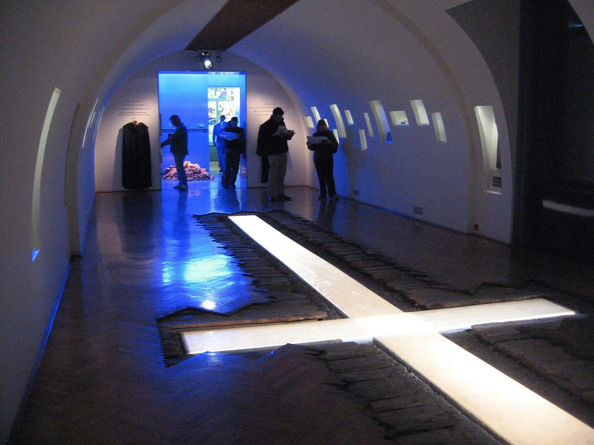 The Churches room on the first floor of the House of Terror Museum, a lit cross sunk into the floor of a dark vaulted corridor