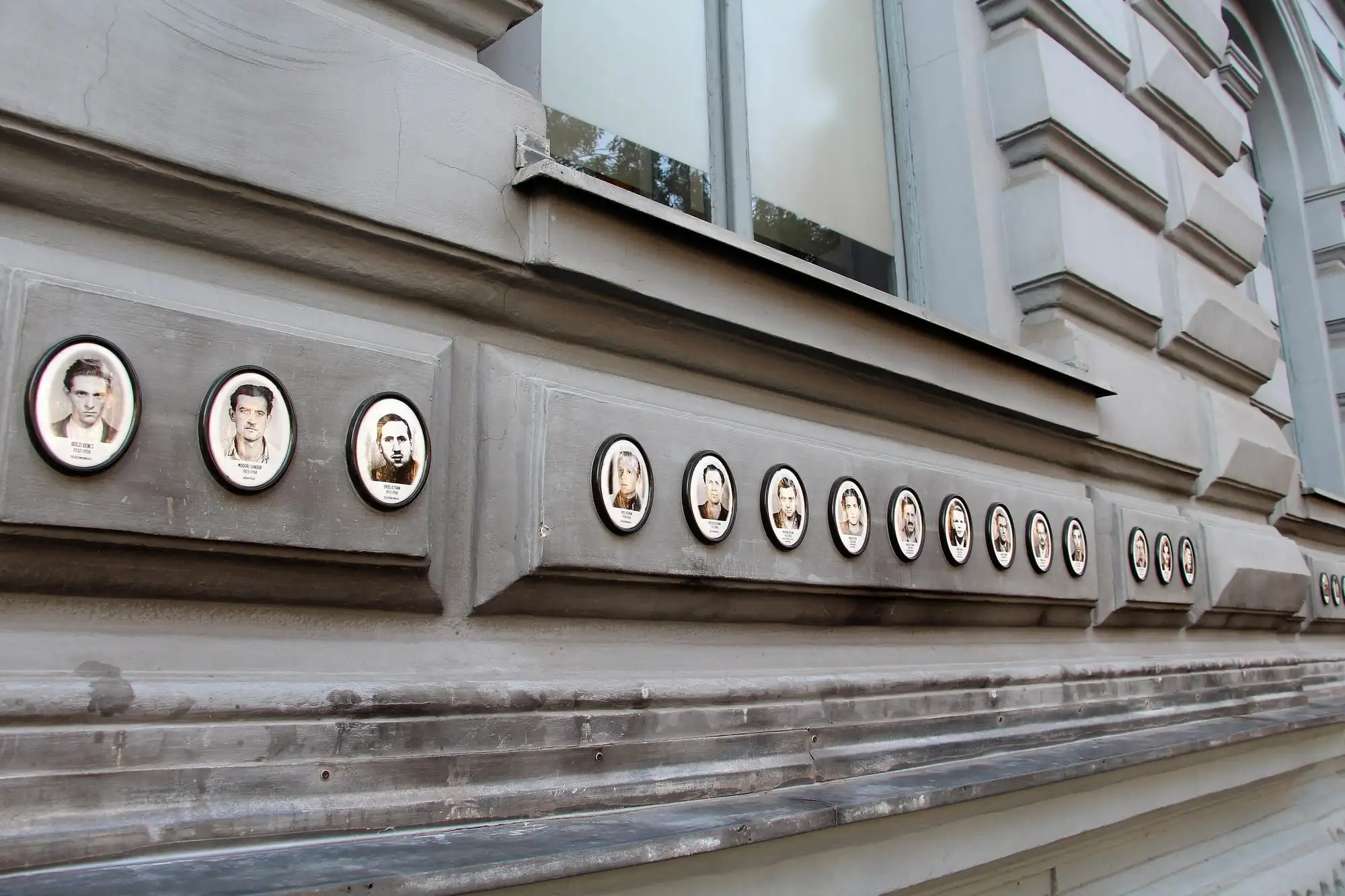 Portrait medallions of victims set along the black steel canopy of the House of Terror Museum at Andrássy út 60 in Budapest