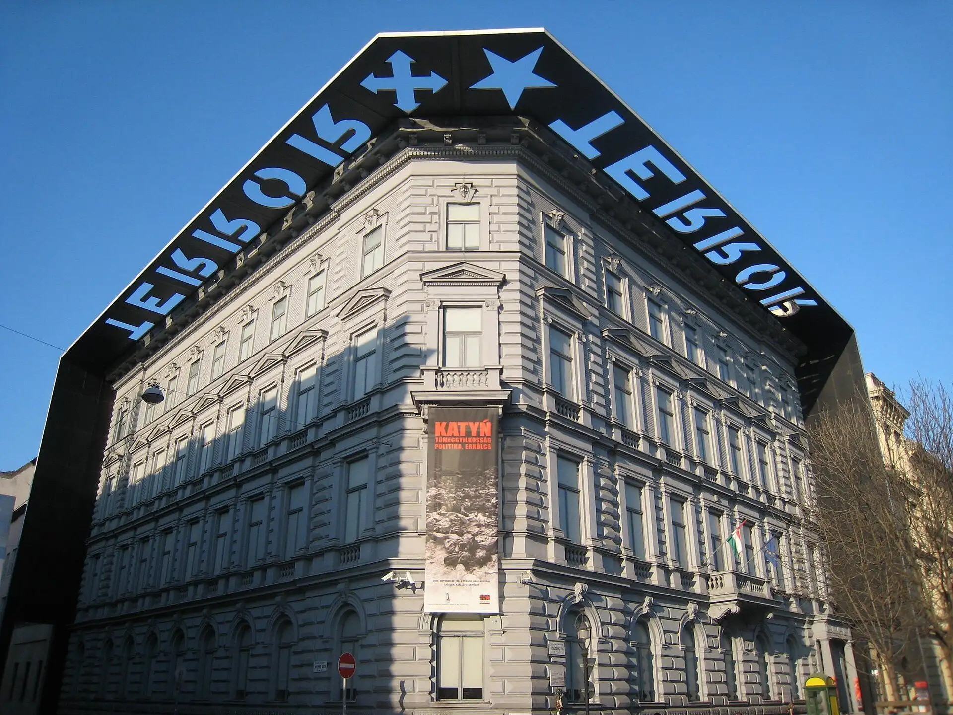 The House of Terror Museum on a sunny day, with the word TERROR, cut into the black entablature, falling as a shadow on the facade