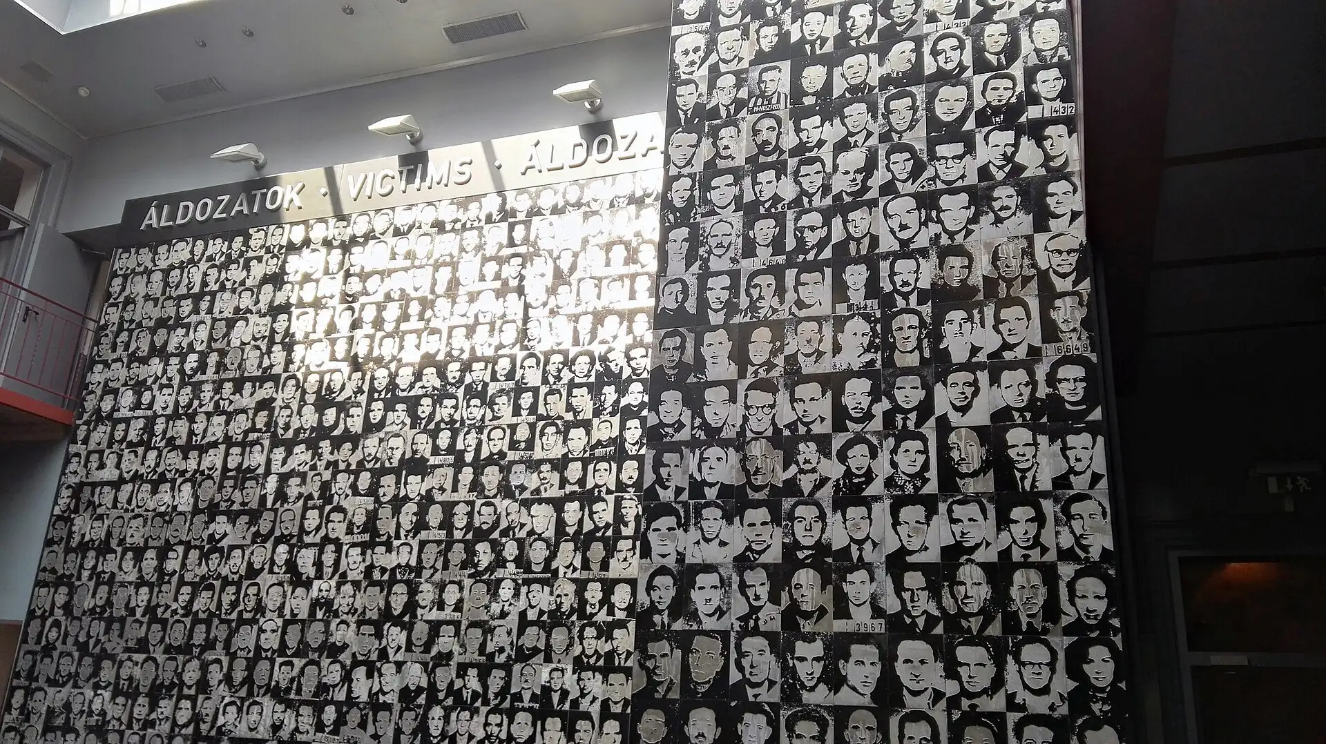 The wall of victims' portraits in the atrium of the House of Terror Museum, rising the full height of the building under the words ÁLDOZATOK, VICTIMS