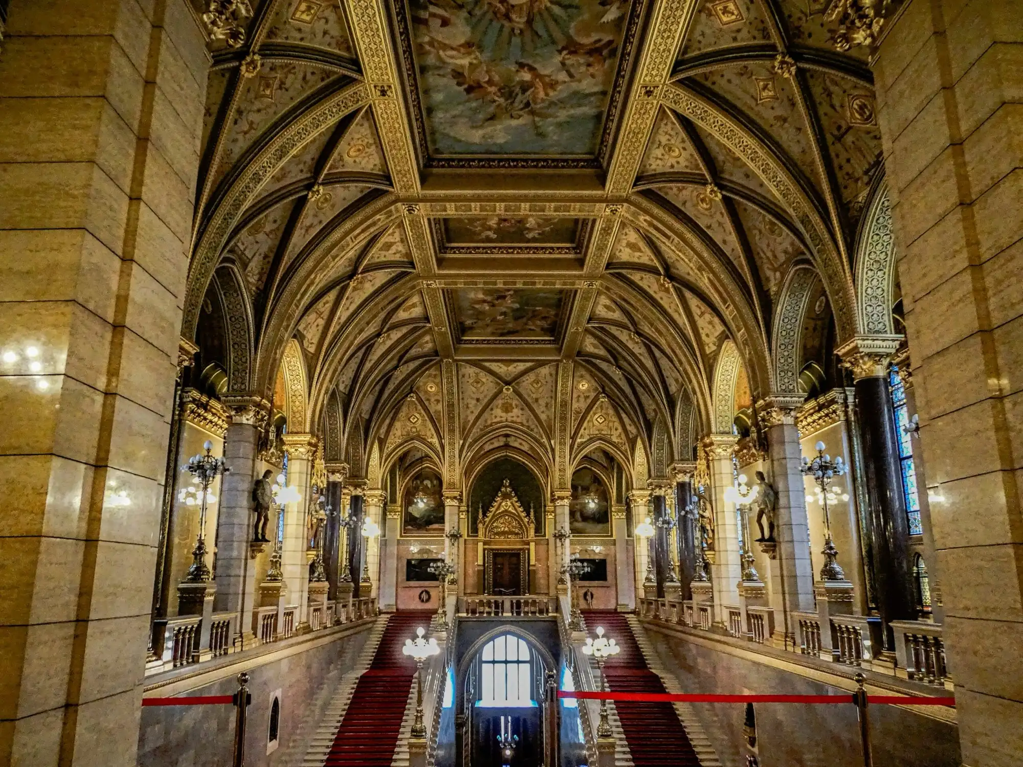 Hungarian Parliament Grand Staircase with red carpet and vaulted gold ceiling