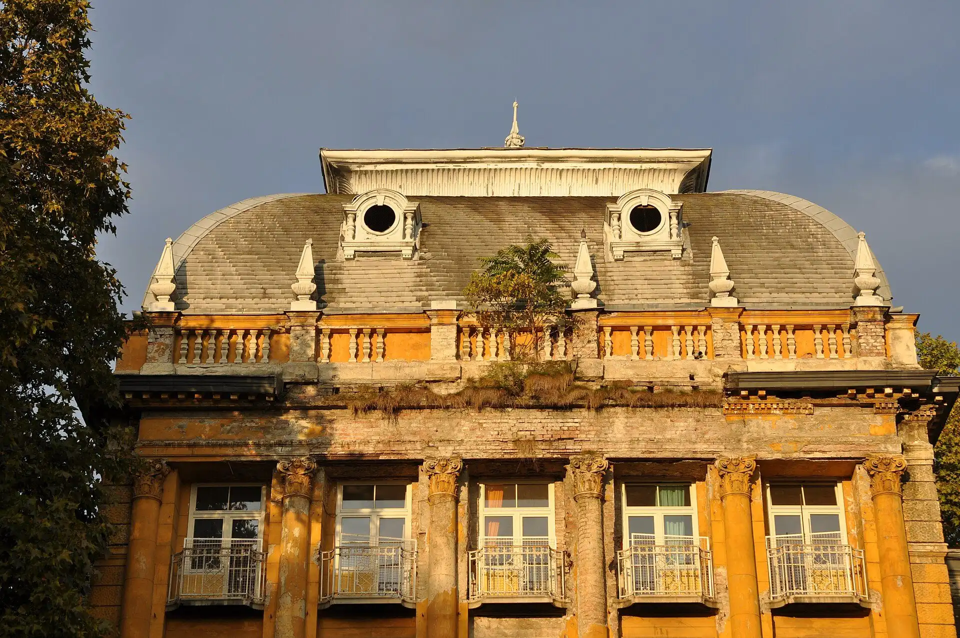 Evening light on the ornate upper storeys and mansard roof of the old spa building at Lukács Thermal Bath