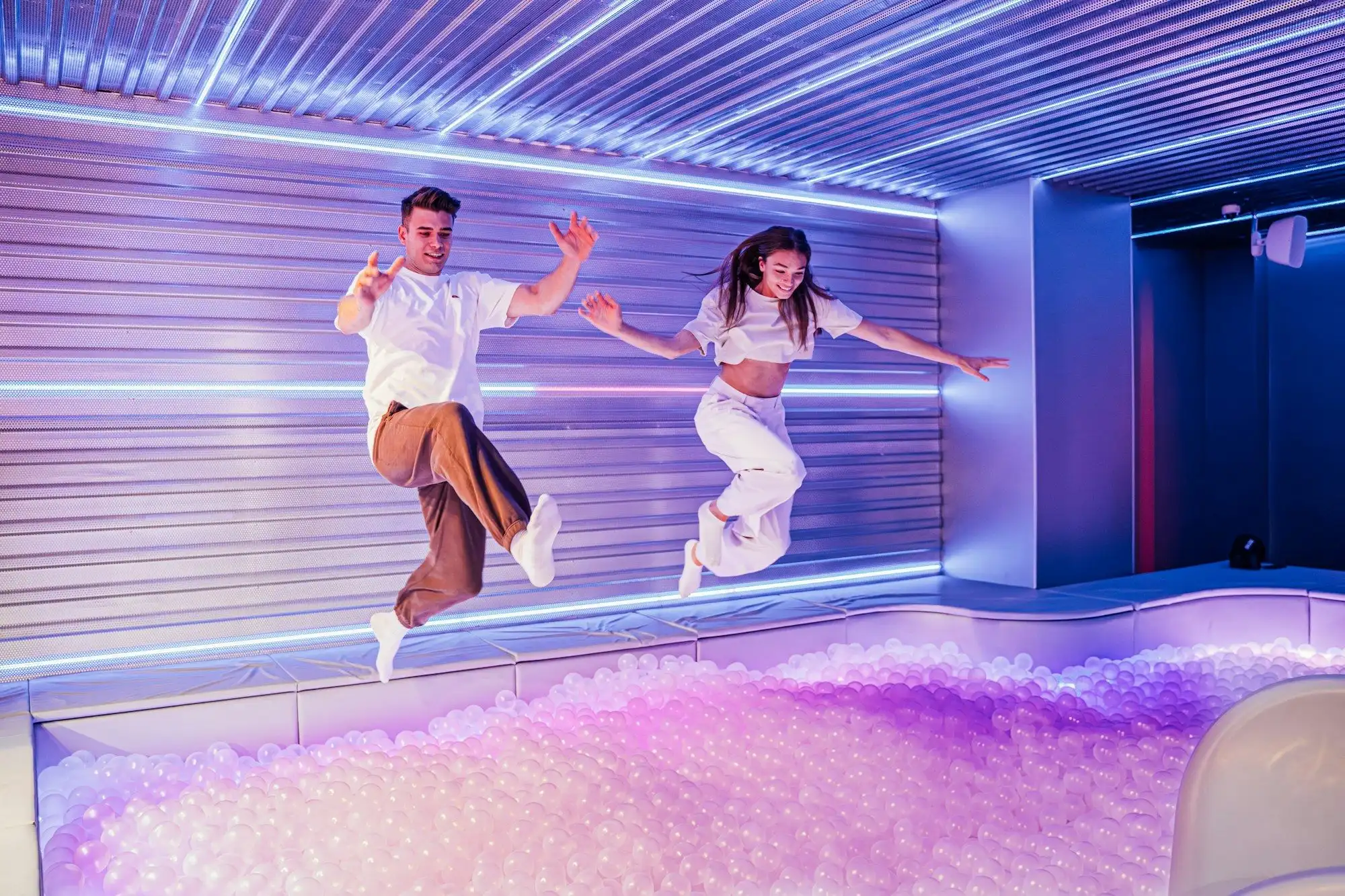 Two visitors jumping on a set with a floor-to-ceiling LED wall at Madame Tussauds Budapest