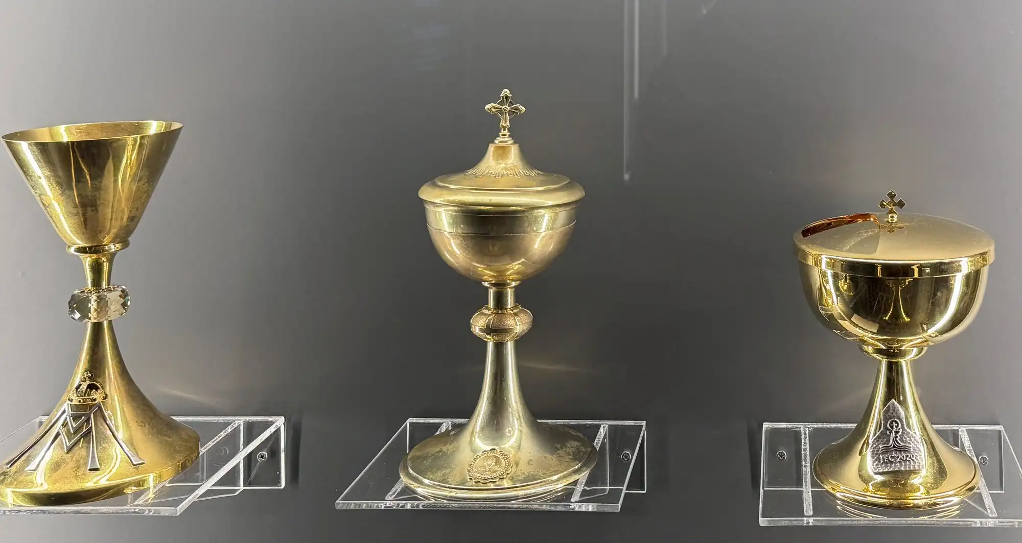 Three gilded chalices in a display case in the ecclesiastical collection of Matthias Church