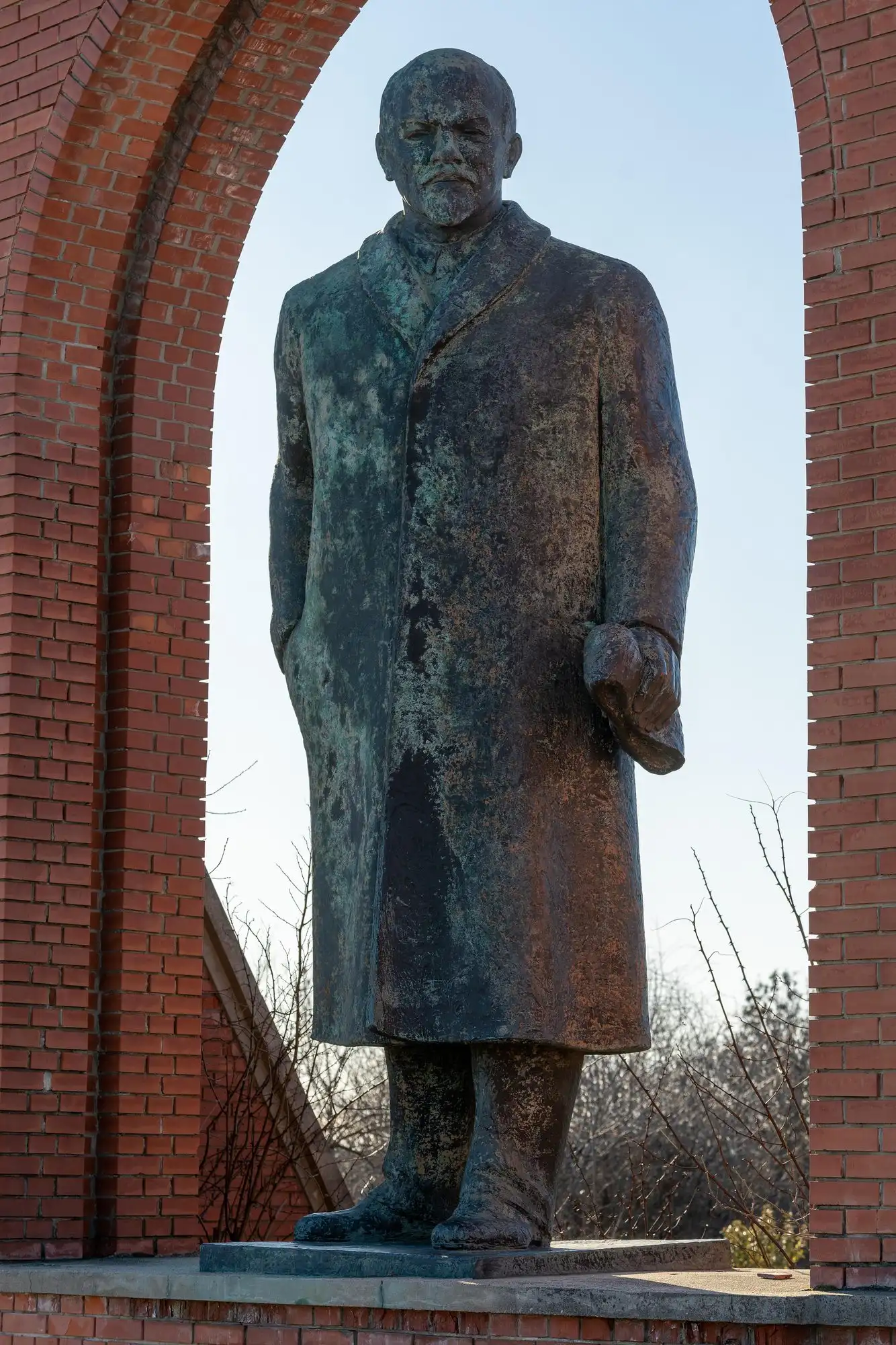 Pál Pátzay's bronze statue of Lenin standing in an arch of the brick entrance facade at Memento Park