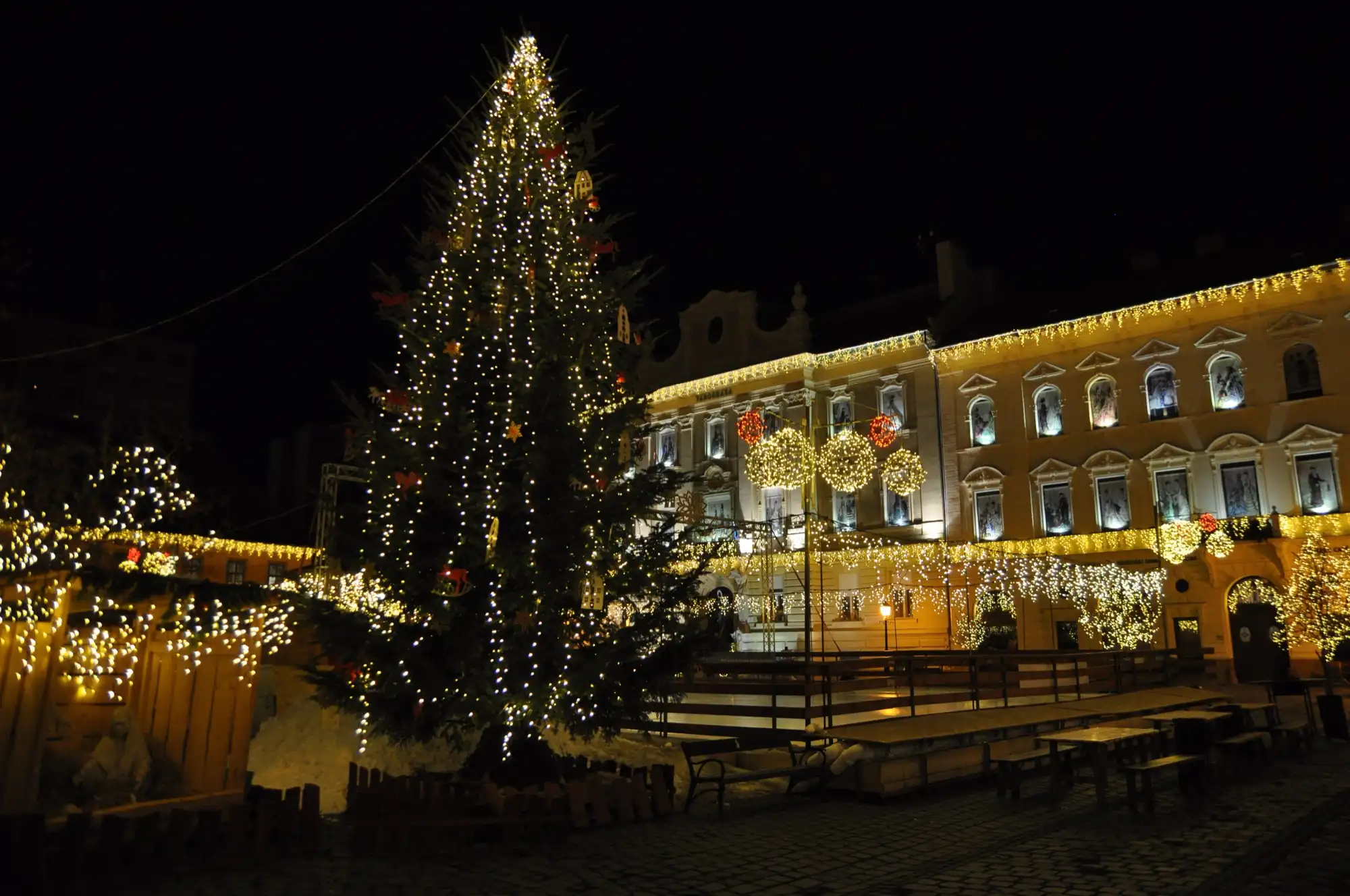 The Christmas tree and the Town Hall outlined in lights on Fő tér in Óbuda during the Advent market