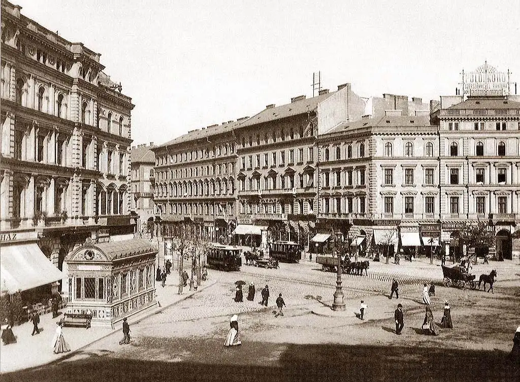 Oktogon on Andrássy Avenue photographed in 1896, with horse carriages on the road and the finished blocks standing on its corners