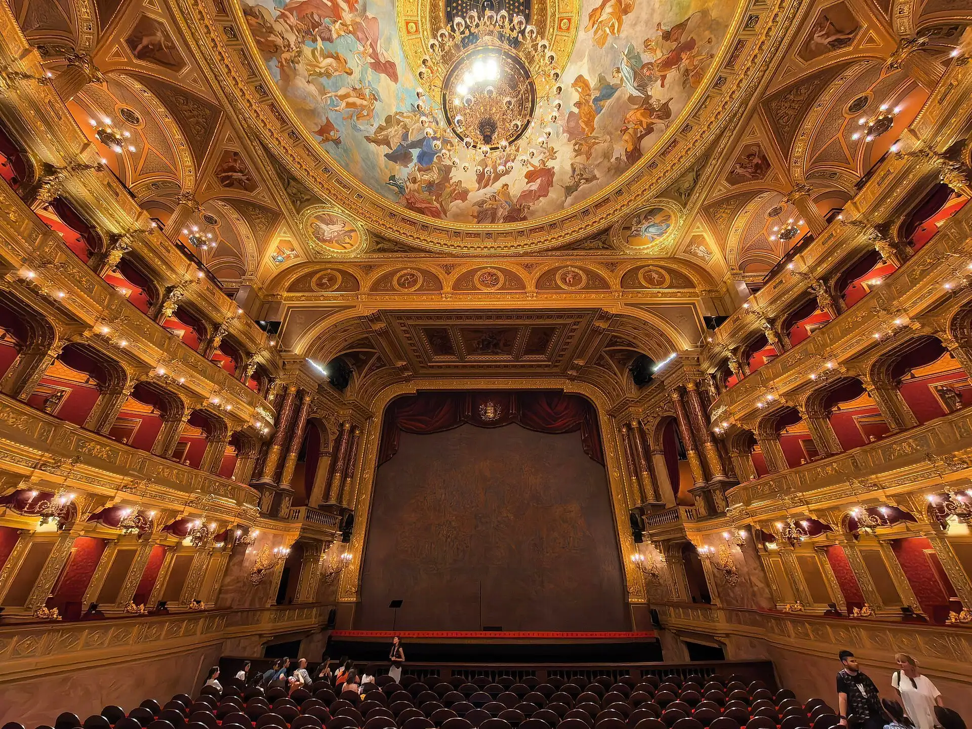 The horseshoe auditorium of the Hungarian State Opera House, its three tiers of gilded boxes curving round towards the stage
