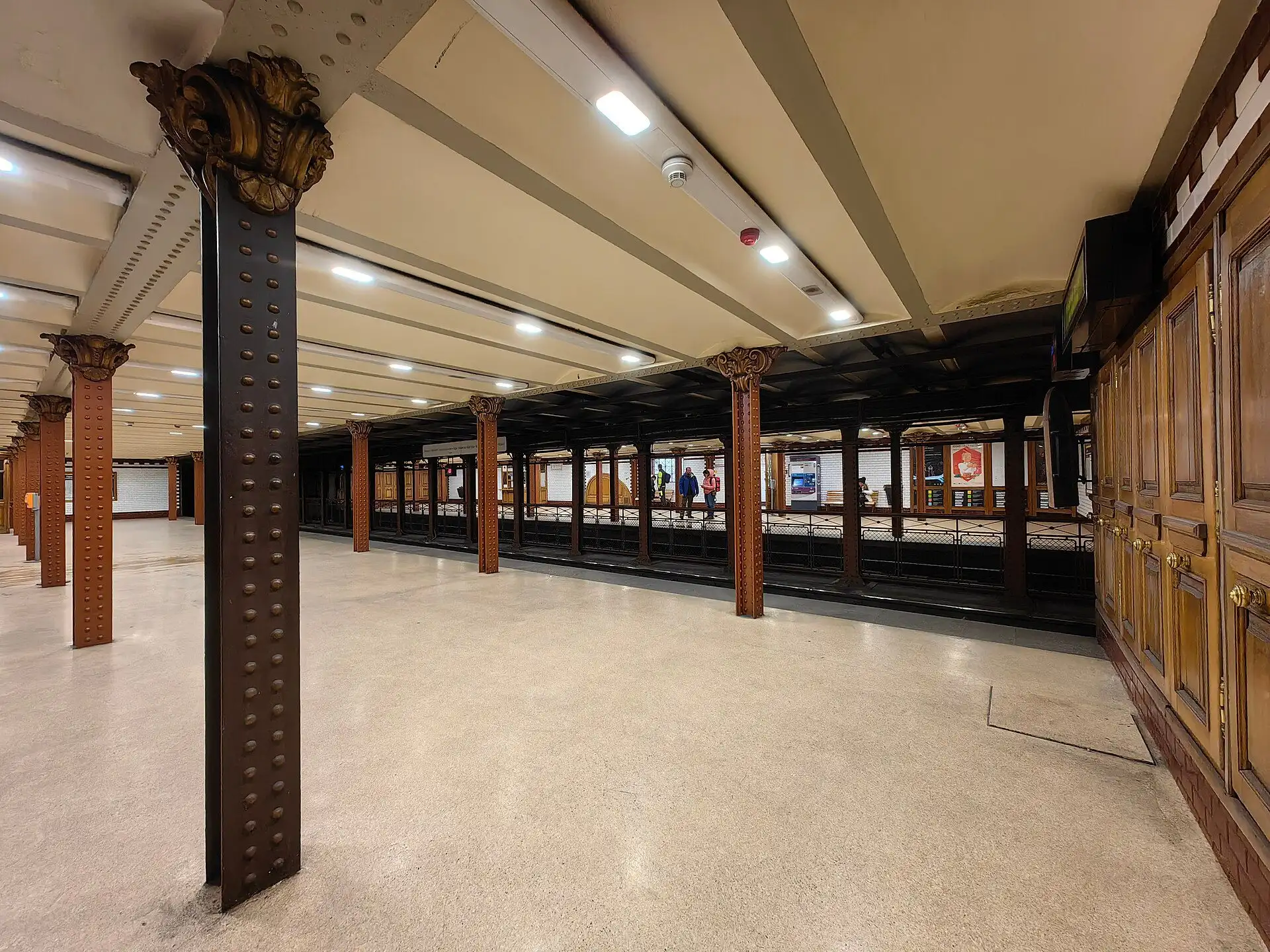 The restored platform of Opera station on the M1 line, with cast-iron columns, brown tiling and the low vaulted ceiling of the Millennium Underground