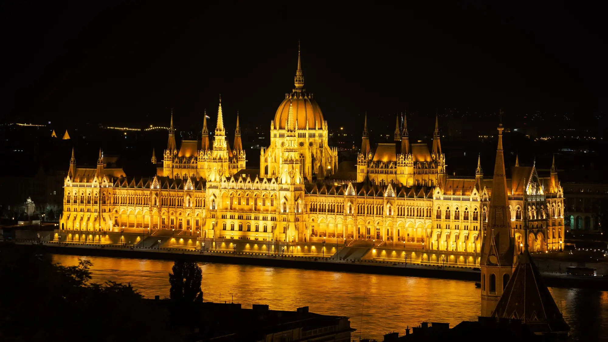 The floodlit Parliament reflected in the Danube, seen from the Buda side of the river