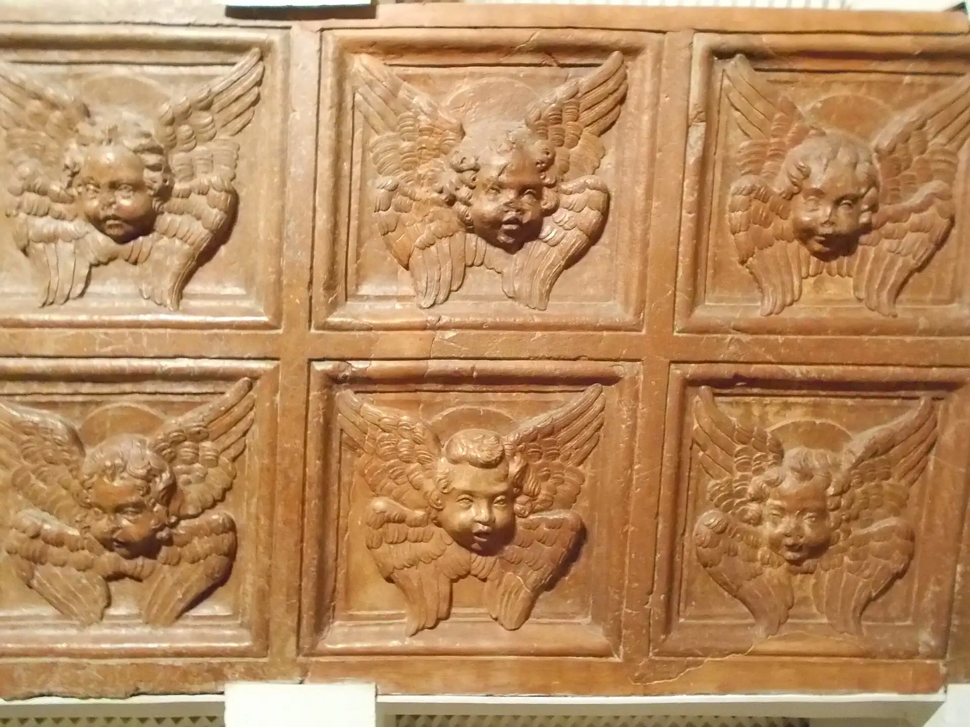 Six carved cherub heads from a Renaissance coffered ceiling, displayed in the Renaissance Room in the cellars of the Budapest History Museum