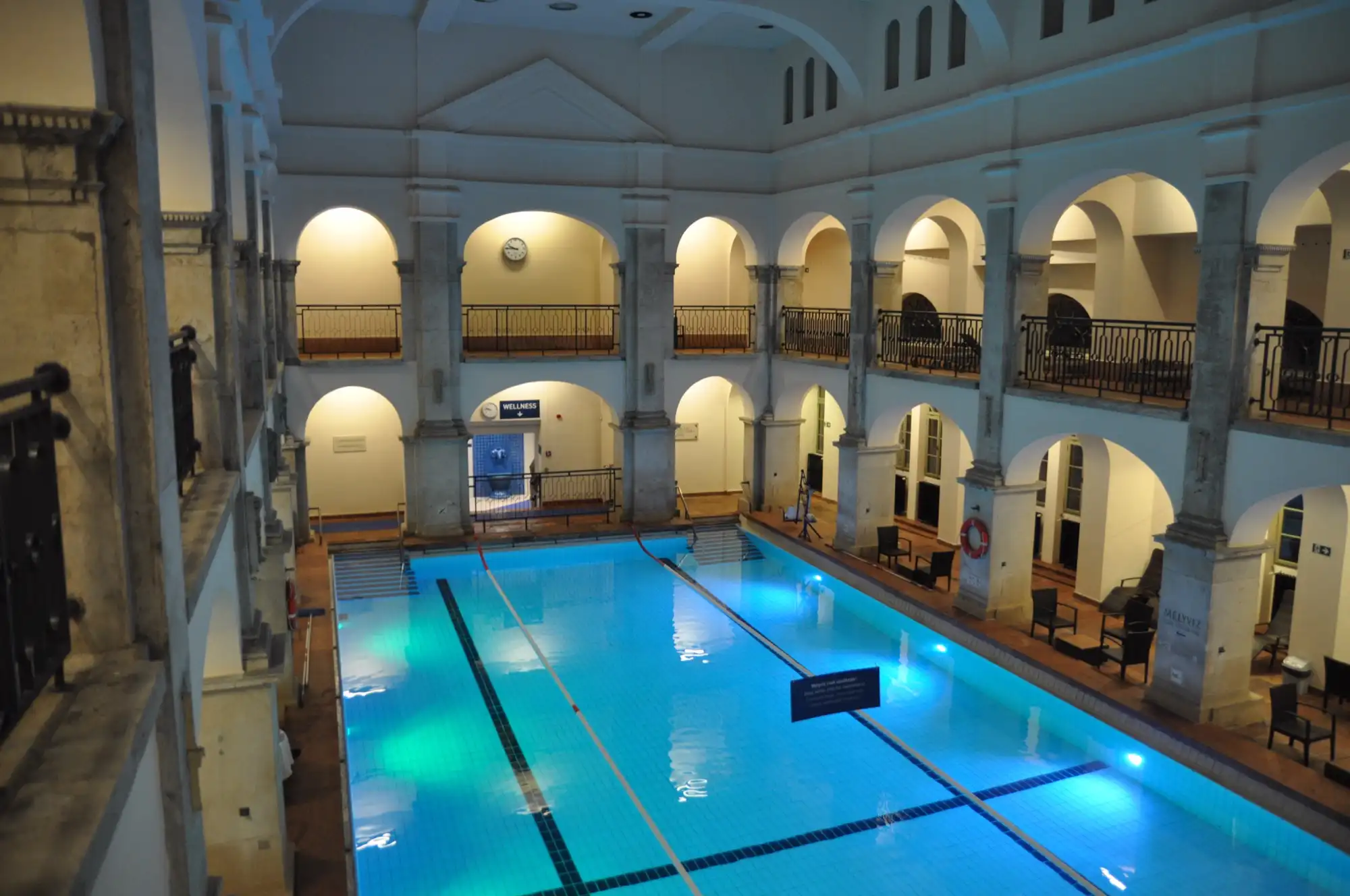 Arcaded swimming pool hall at Rudas Thermal Bath in Budapest, lit blue at night