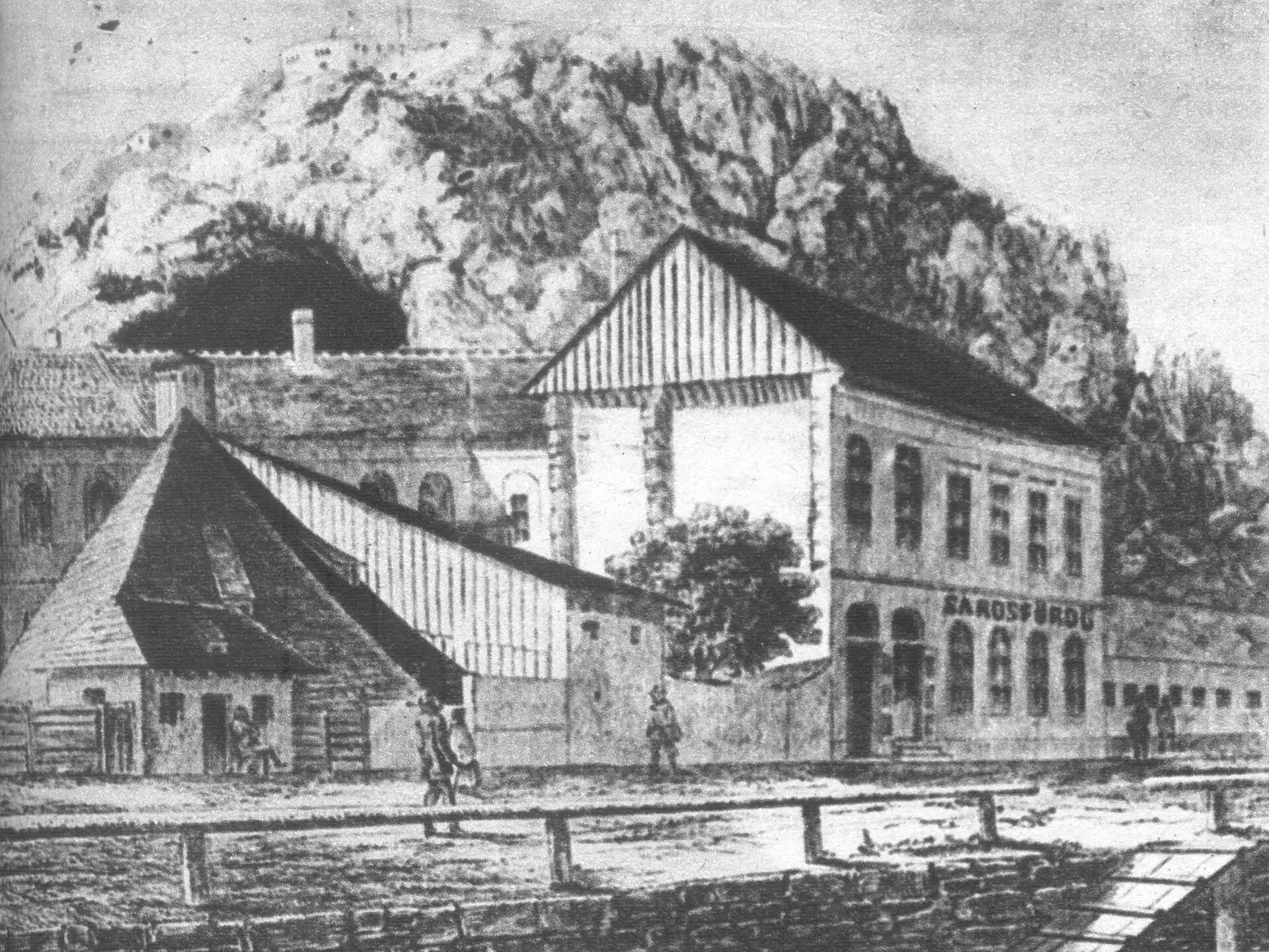 An old engraving of the Sáros Bath, the Mud Bath, a low building at the foot of Gellért Hill with the rock rising behind it