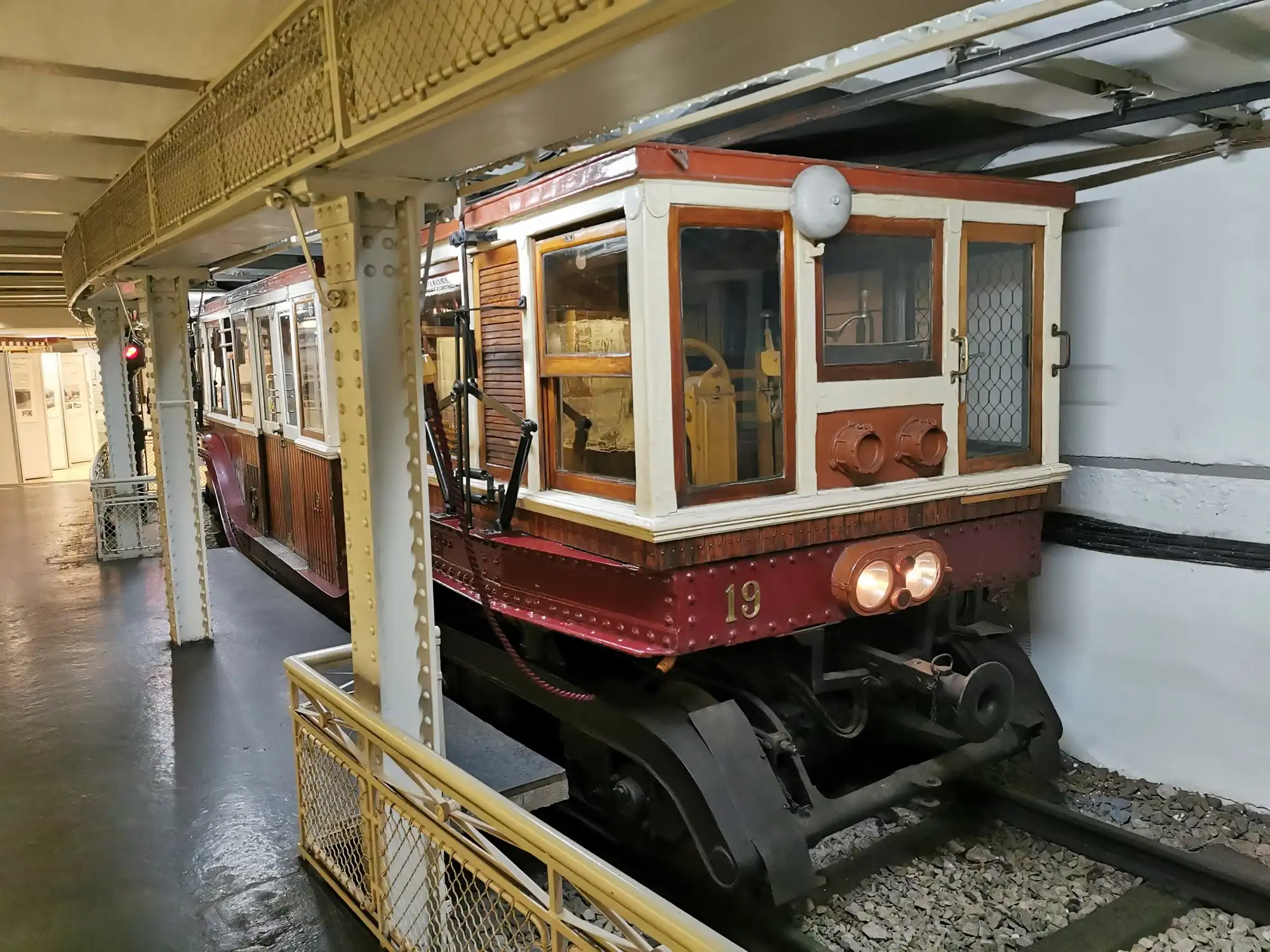 Car number 19 of the Millennium Underground, in red, cream and timber, standing on the old track inside the Underground Railway Museum in Budapest