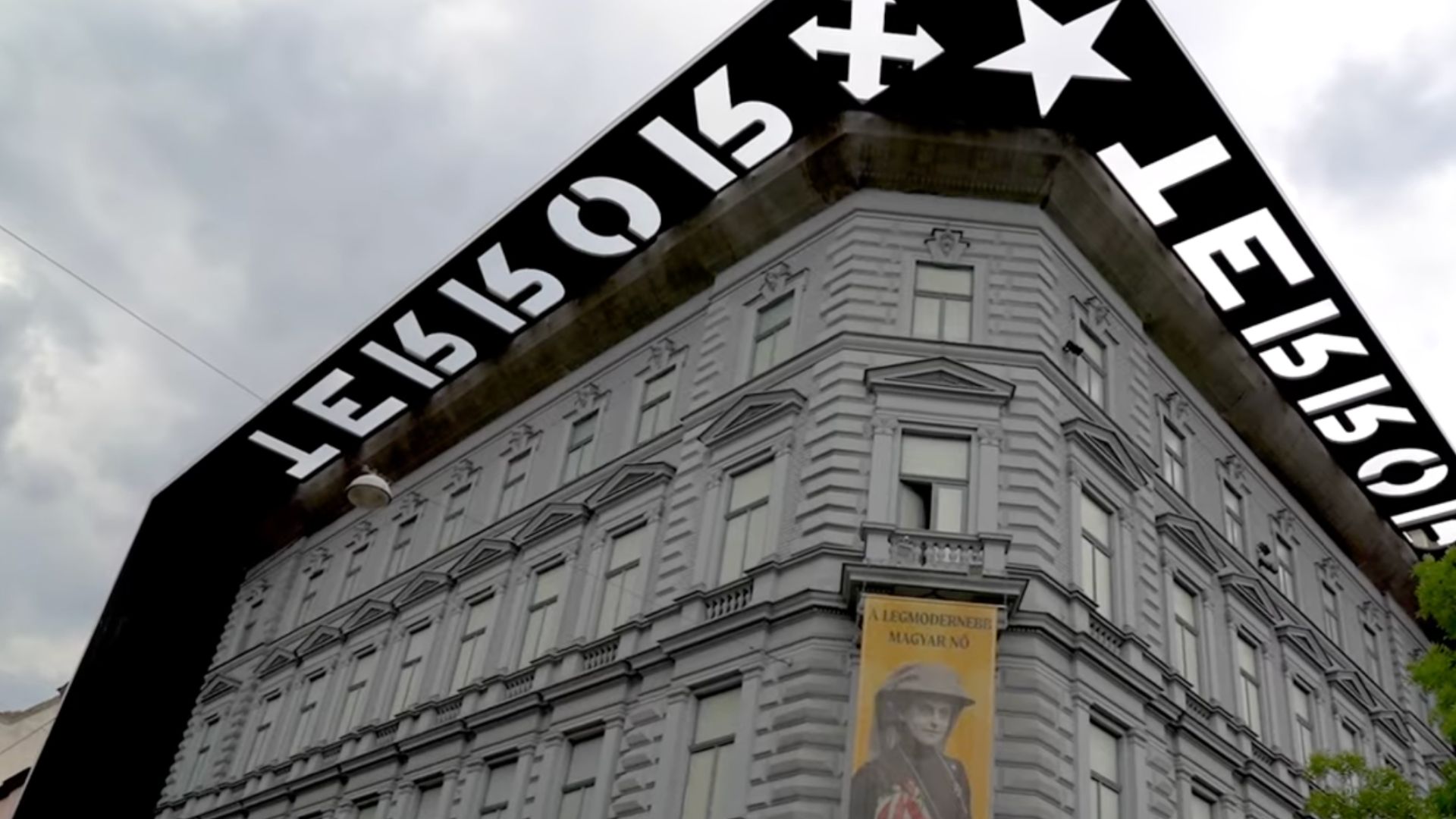 The House of Terror Museum located on Andrássy Avenue in Budapest, Hungary, with its distinctive overhanging sign.