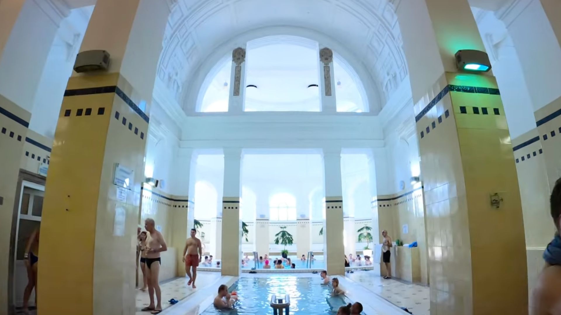Indoor pool area with high ceiling and white columns at Széchenyi Thermal Bath in Budapest