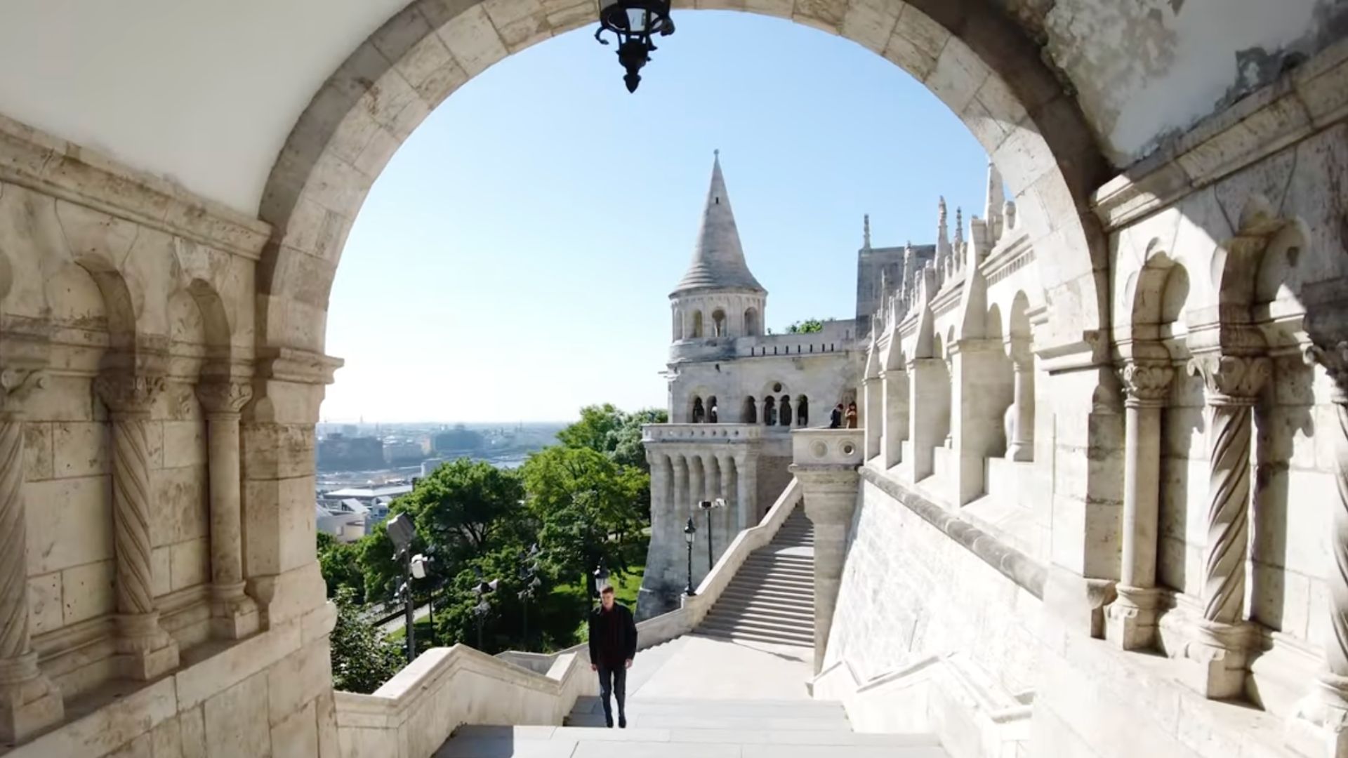 An arched walkway with statues and steps leading to the upper terraces of Fisherman's Bastion.