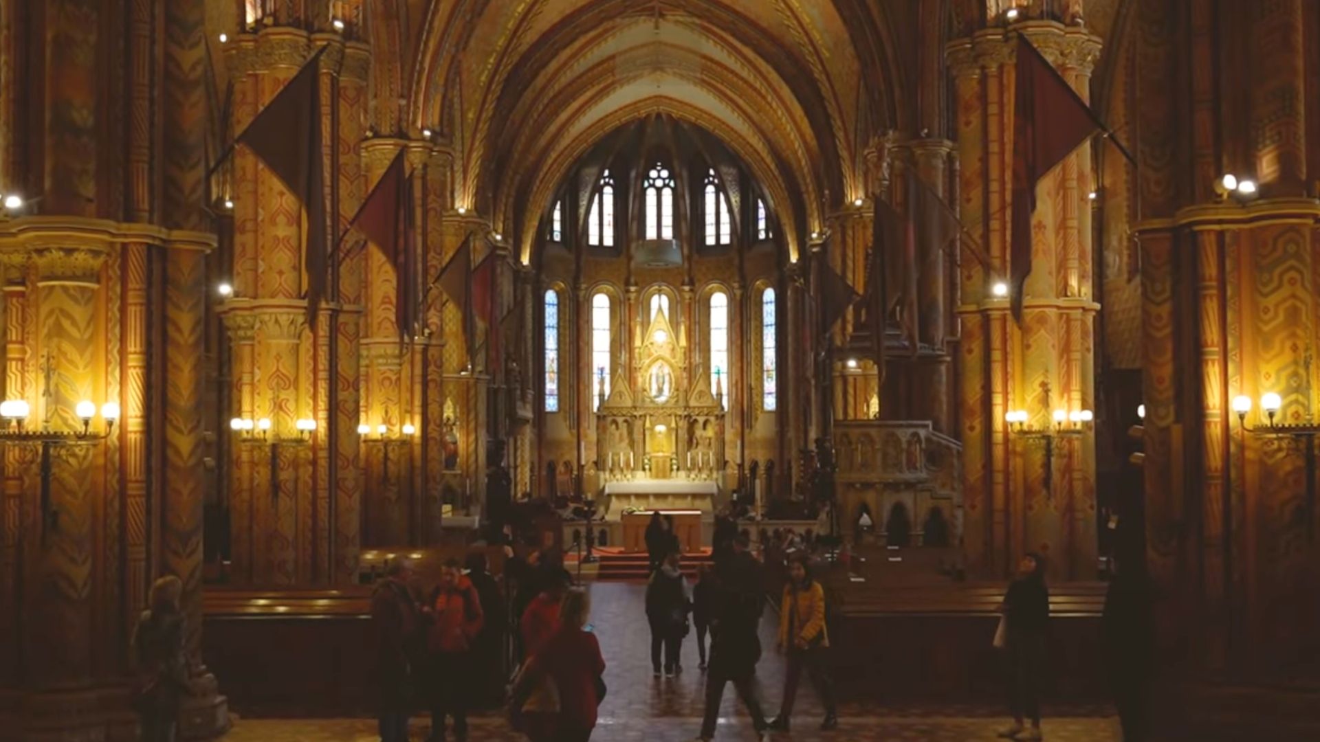 Interior view of Matthias Church with an ornate altar and stained glass windows.