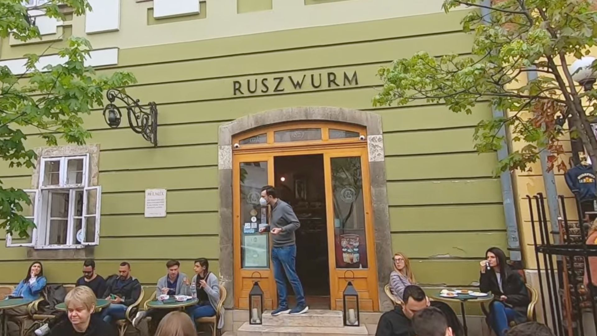 Exterior of the Ruszwurm Cafe with people sitting outside.